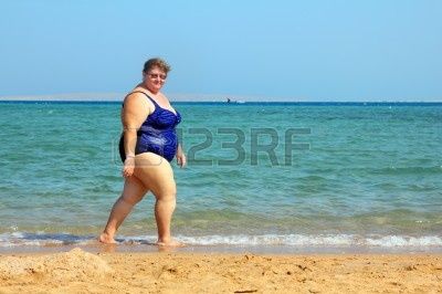 10213901-overweight-woman-walking-on-sea-beach.jpg