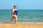 10213901-overweight-woman-walking-on-sea-beach.jpg